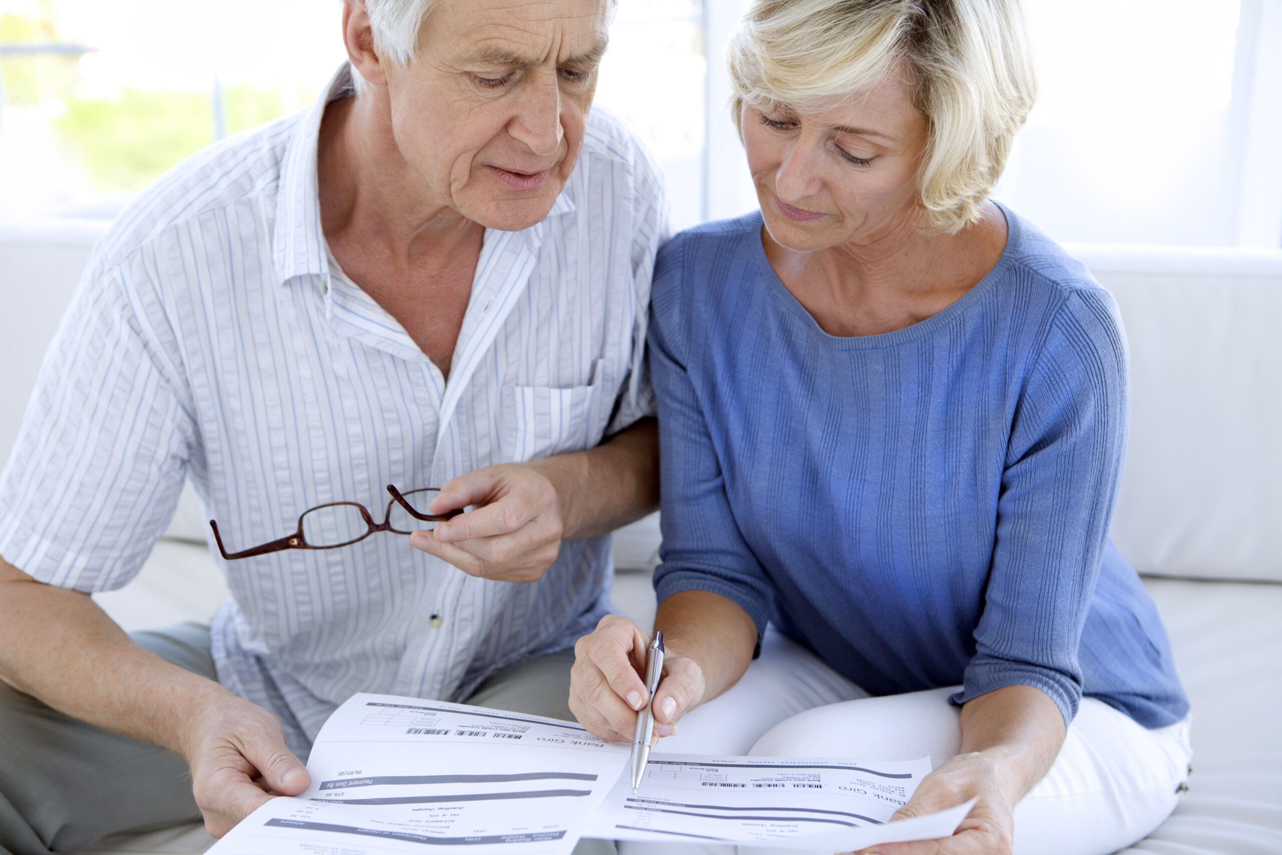 senior couple reviewing costly medical bills